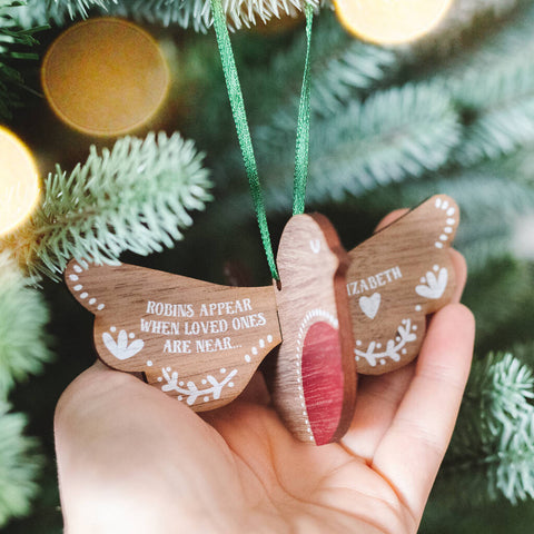 A wooden robin bird Christmas tree decoration. The wings have been personalised with the words 'robins appear when loved ones are near'.